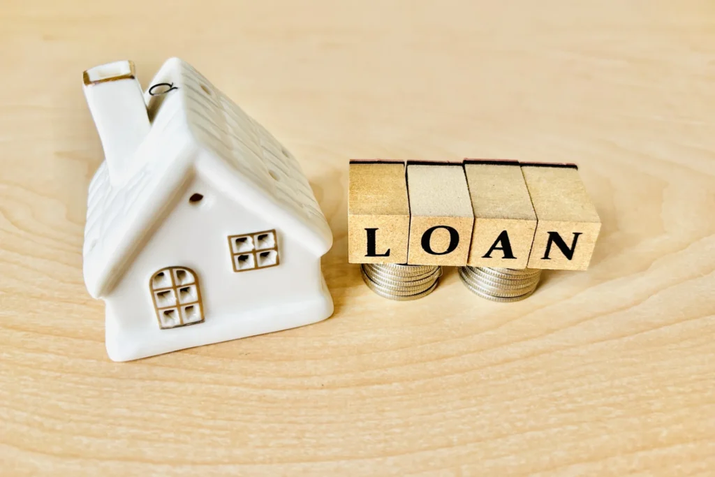 家の形をした置き物と「LOAN」の文字が書かれた木製のブロック