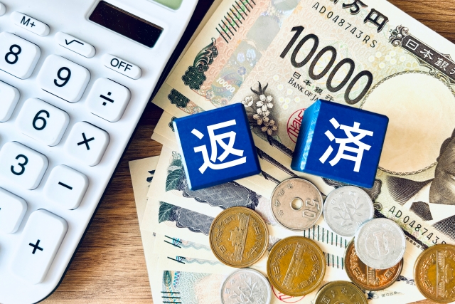 日本円の上に「返」「済」と書かれtがブロックが置いてある