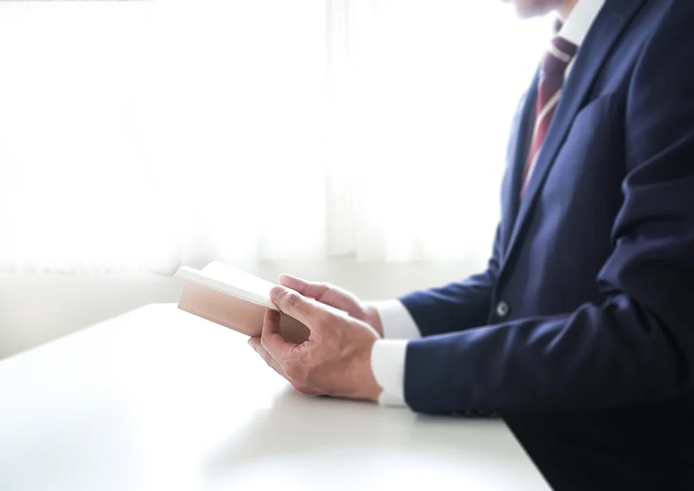 本を読むスーツ姿の人