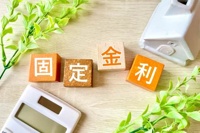 テーブルの上に「固」「定」「金」「利」と書かれたブロックが置いてある