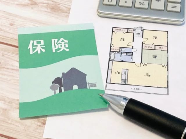 通帳の上に「借入」と書かれた黄色の吹き出しが置かれ、ピンクの豚の貯金箱、電卓、観葉植物が並んでいる