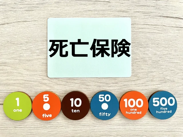 死亡保険と書かれた四角いプレートと、「1」「5」「10」「50」「100」「500」と書かれた丸いプレート
