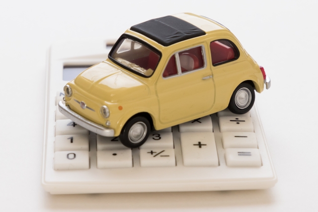 電卓の上に車の模型が置かれている